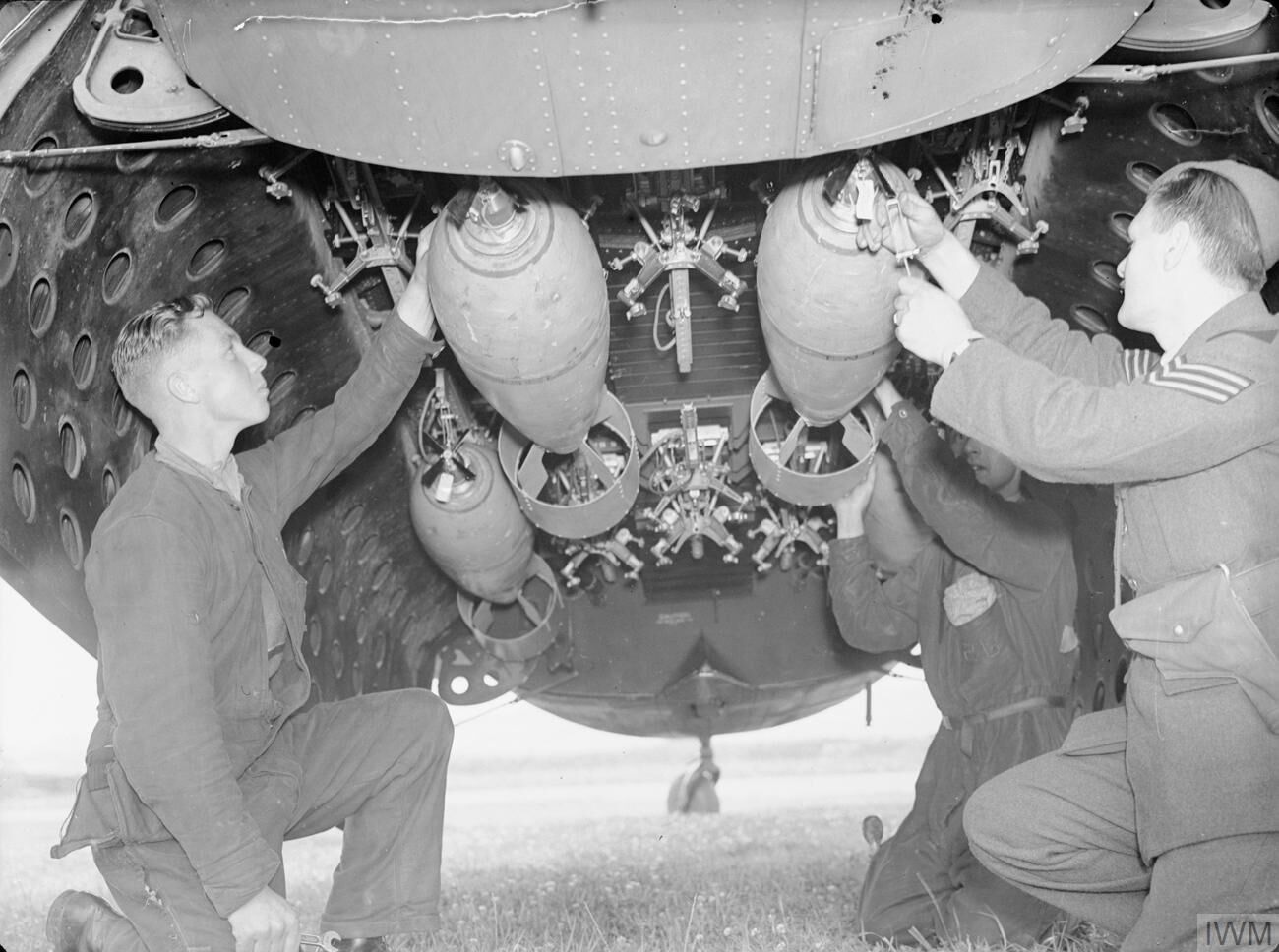 Armourers securing 250-lb bombs into Lockheed Hudson bomb-bay at RAF Leuchars, WWII (IWM CH 979)